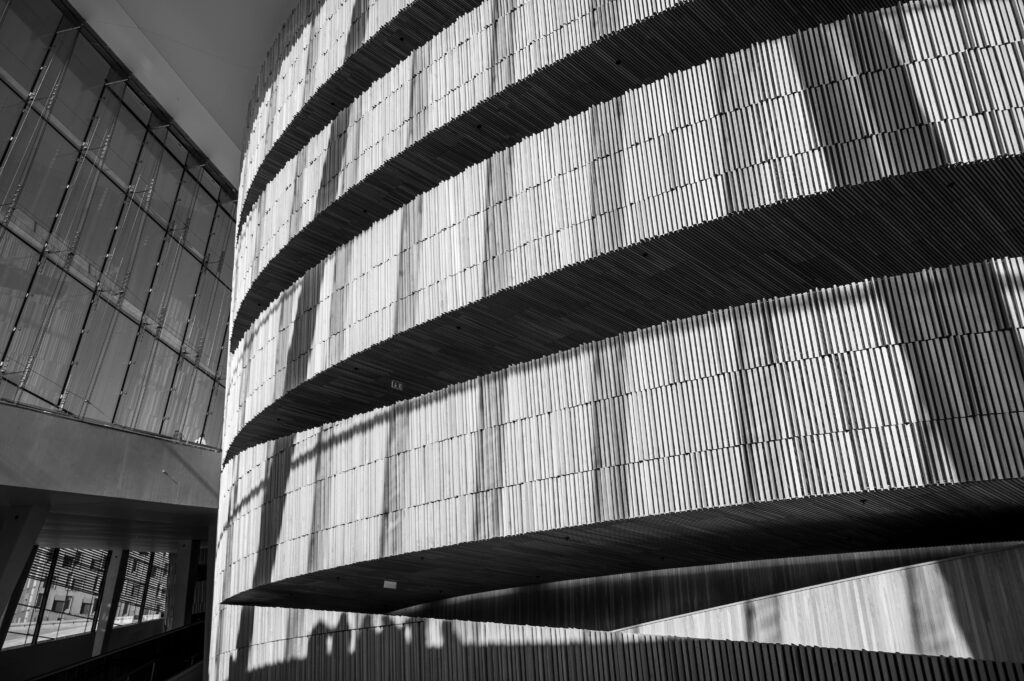 Black and white interior shot of Oslo Opera House showcasing modern curved architecture.