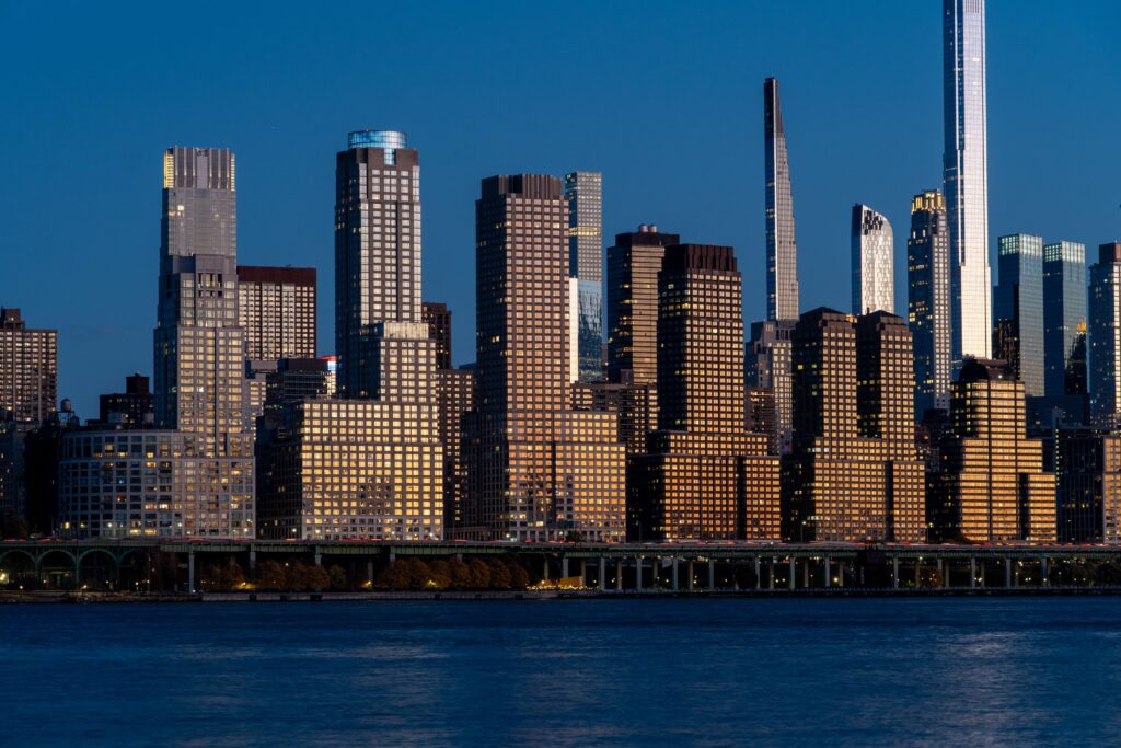 Breathtaking view of the New York City skyline reflecting the evening light against a clear blue sky.