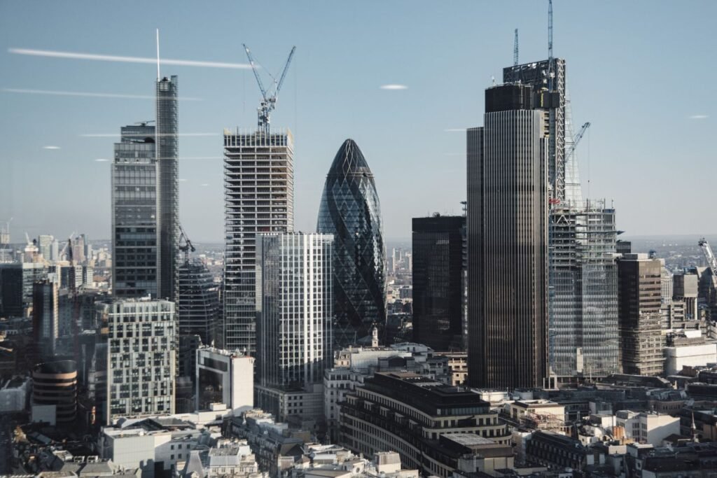 Various shaped modern skyscrapers with glass mirrored facades located in financial district of London against blue sky on sunny day